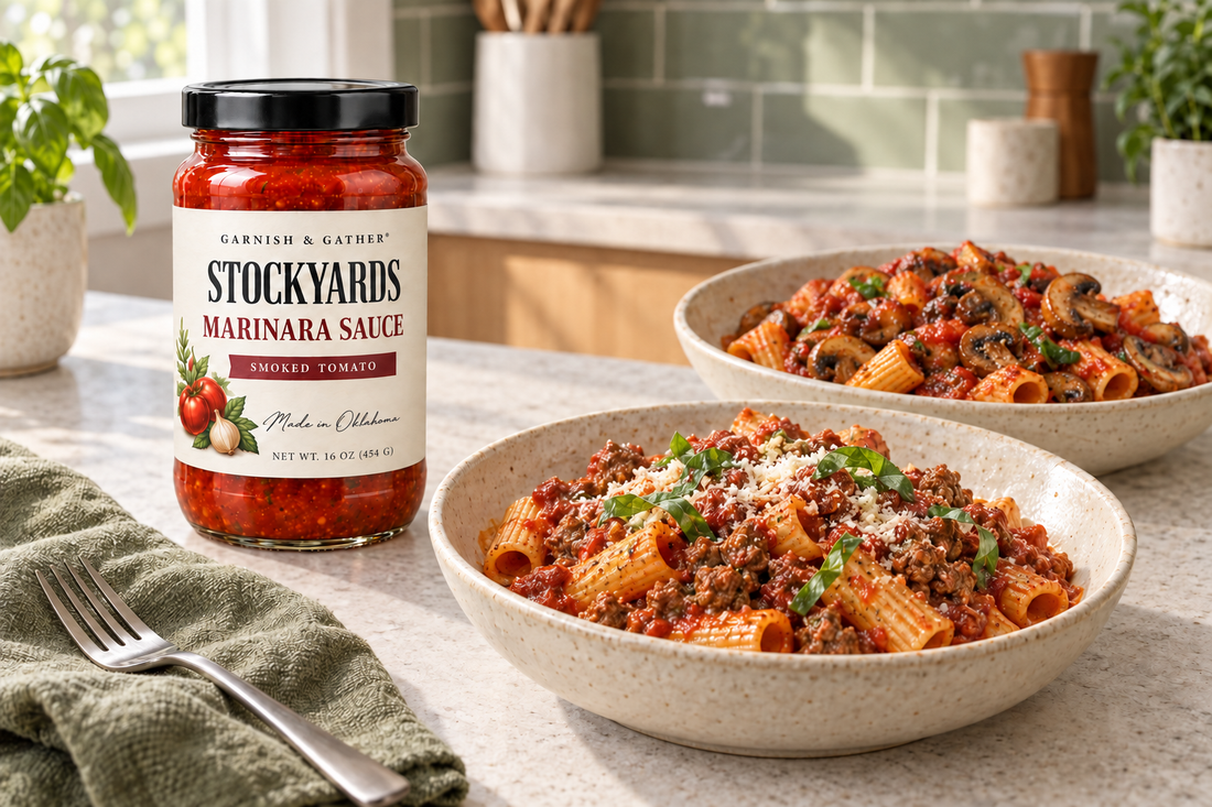 Stockyards Smoked Tomato Marinara Sauce beside bowls of beef marinara pasta and mushroom marinara pasta in a bright kitchen.